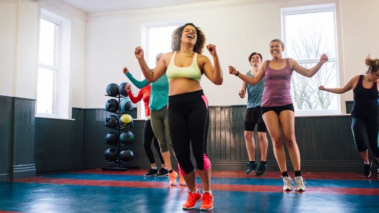 Group fitness participants moving in sync during an upbeat studio workout