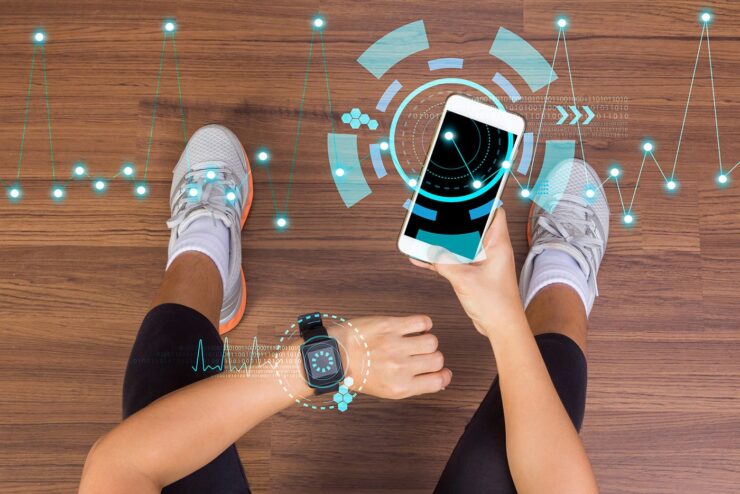 Person checking fitness data on smartphone and smartwatch during workout
