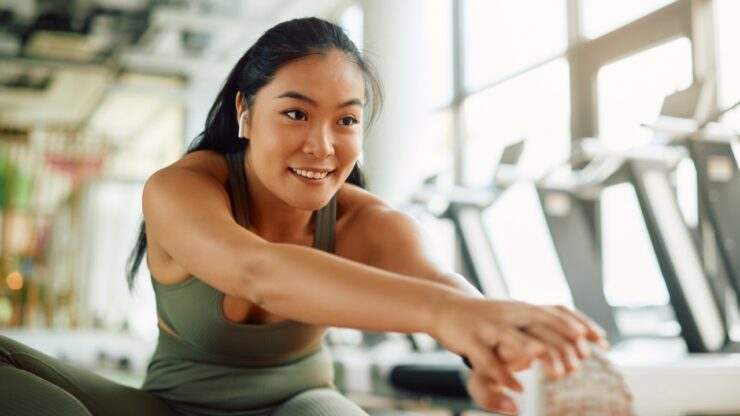 Woman stretching in a gym during a guided fitness session