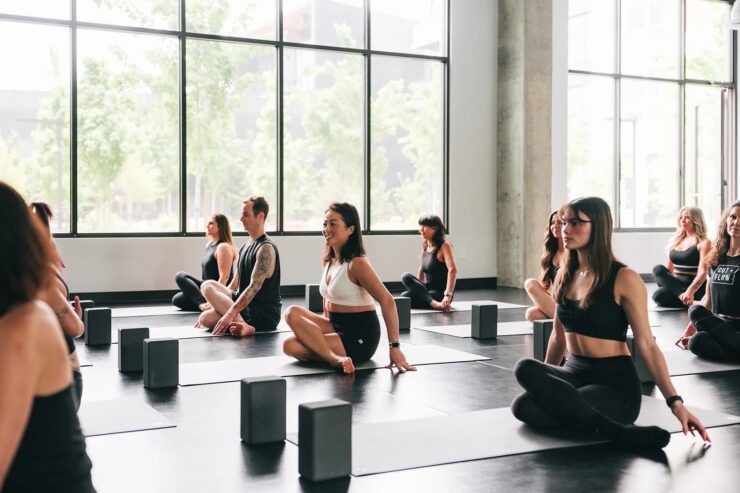 Group fitness participants seated on mats in a structured studio session