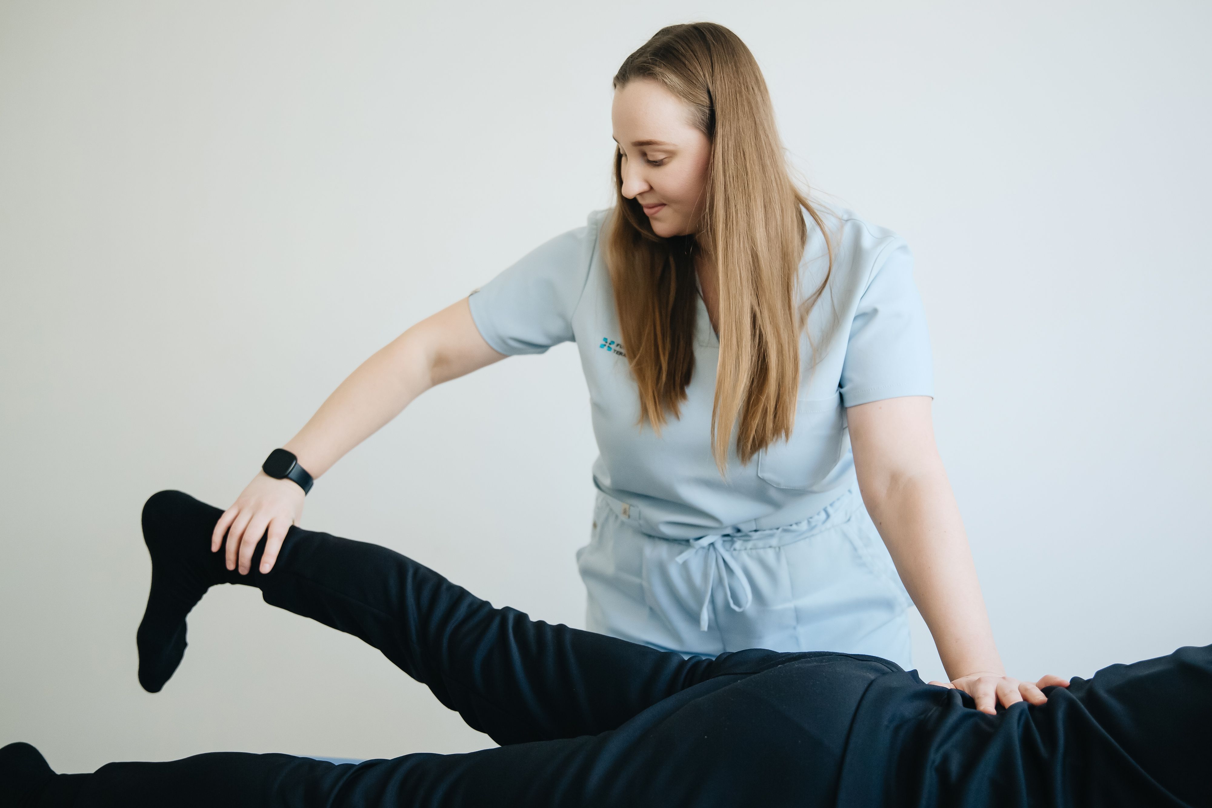 Physiotherapist guiding a patient through leg rehabilitation and recovery